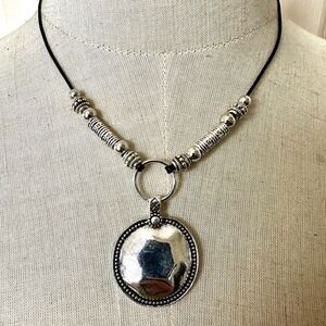 Silver tone pendant necklace on black cord